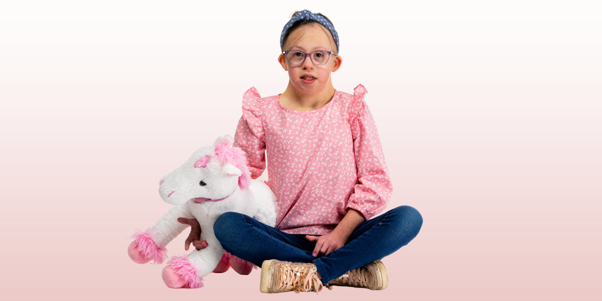 Ellie smiling with her stuffed animal