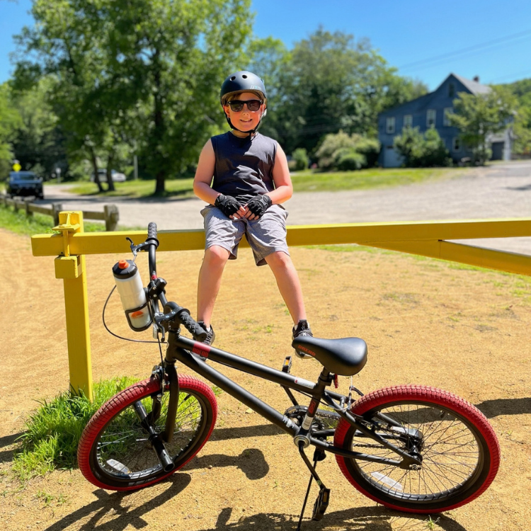 Carson smiling wearing helmet with his bicycle