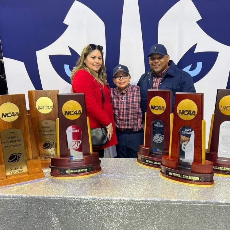 Elijah and his parents with NCAA trophies