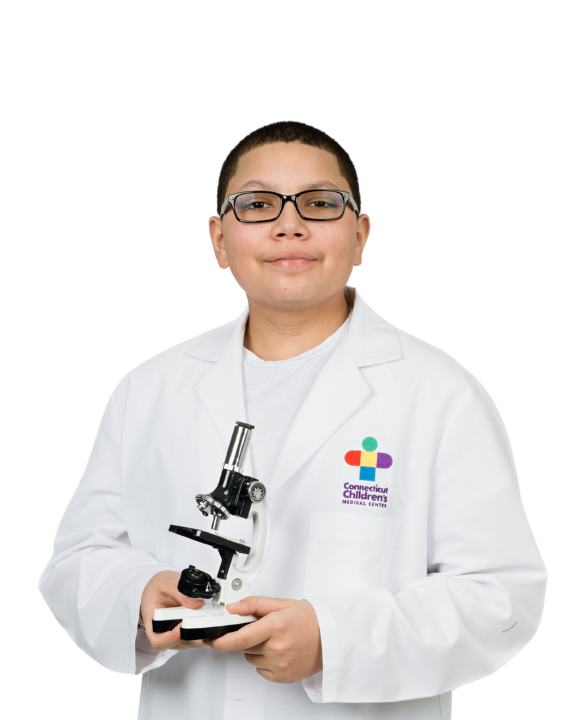 Elijah smiling holding a microscope in a white lab coat