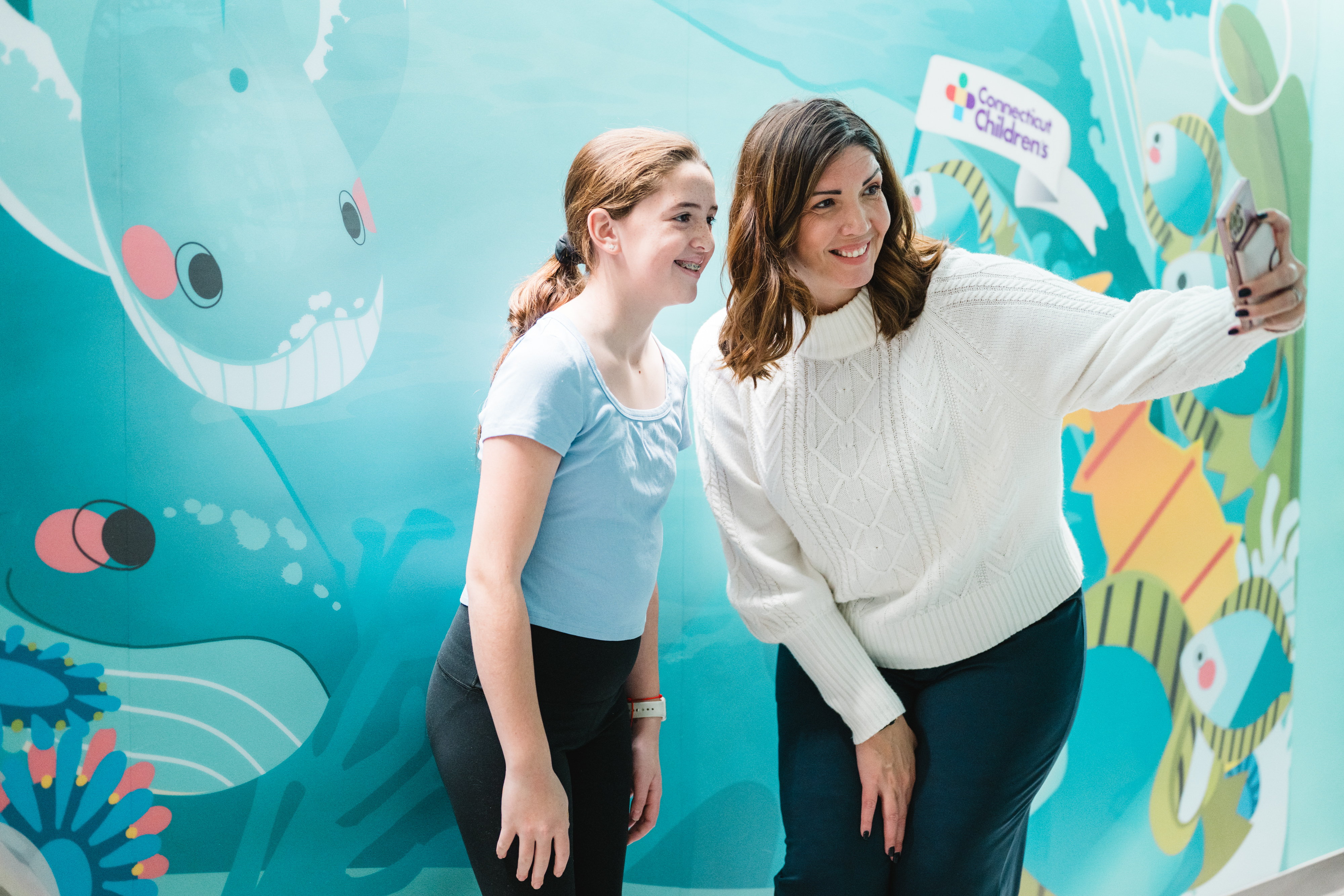 Mom and daughter taking a selfie at the selfie wall