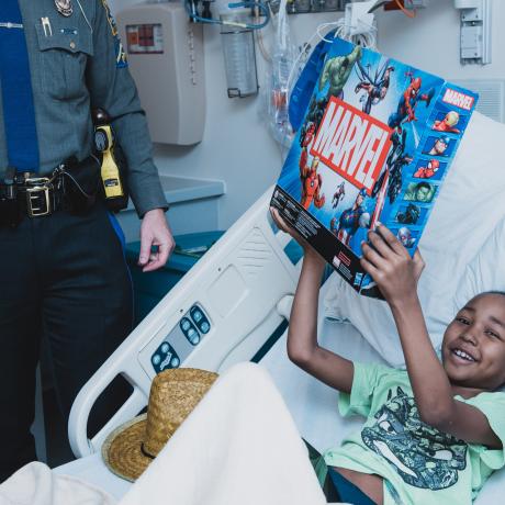 A young boy receives a new toy from Child Life