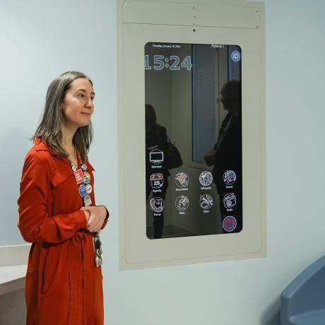 A leader stands in front of the CoWin Media Wall which will aid in entertaining and keeping kids safely connected while being cared for.