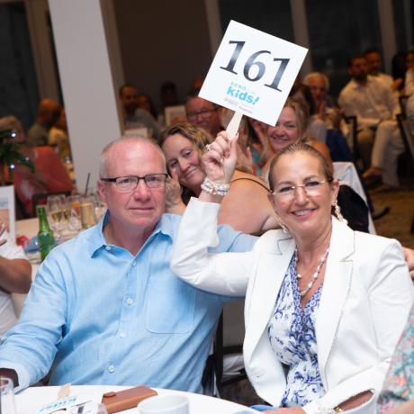 Guests bidding on an auction item and holding up their paddle