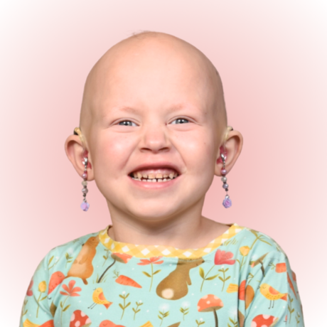 Anastasia smiling with her hearing-aid earrings