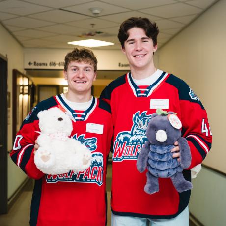 Hartford Wolfpack Player in jerseys with stuffed animals