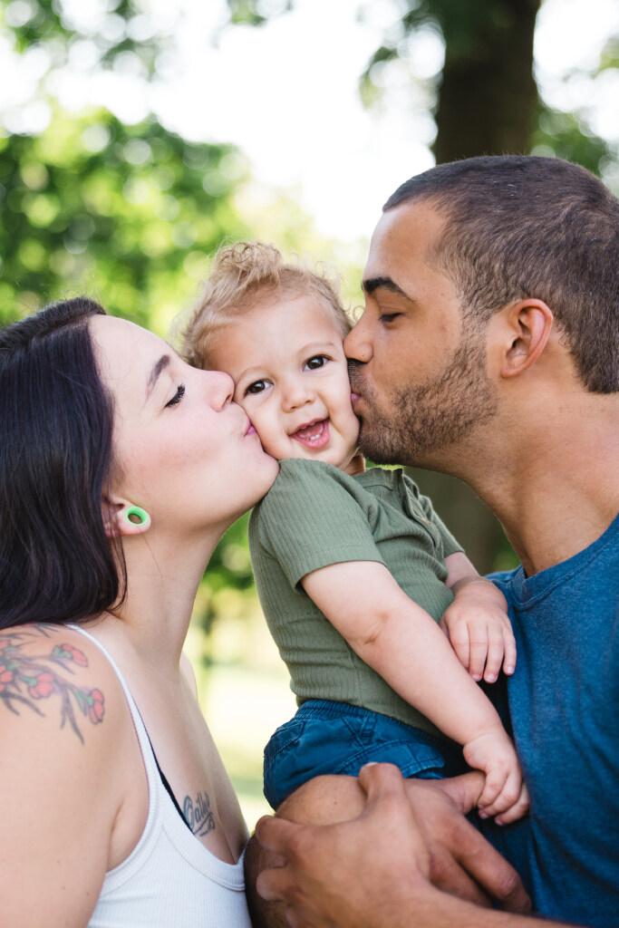 Happy Family Kissing their Baby