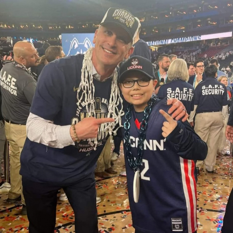Elijah smiling with Dan Hurley after a championship win