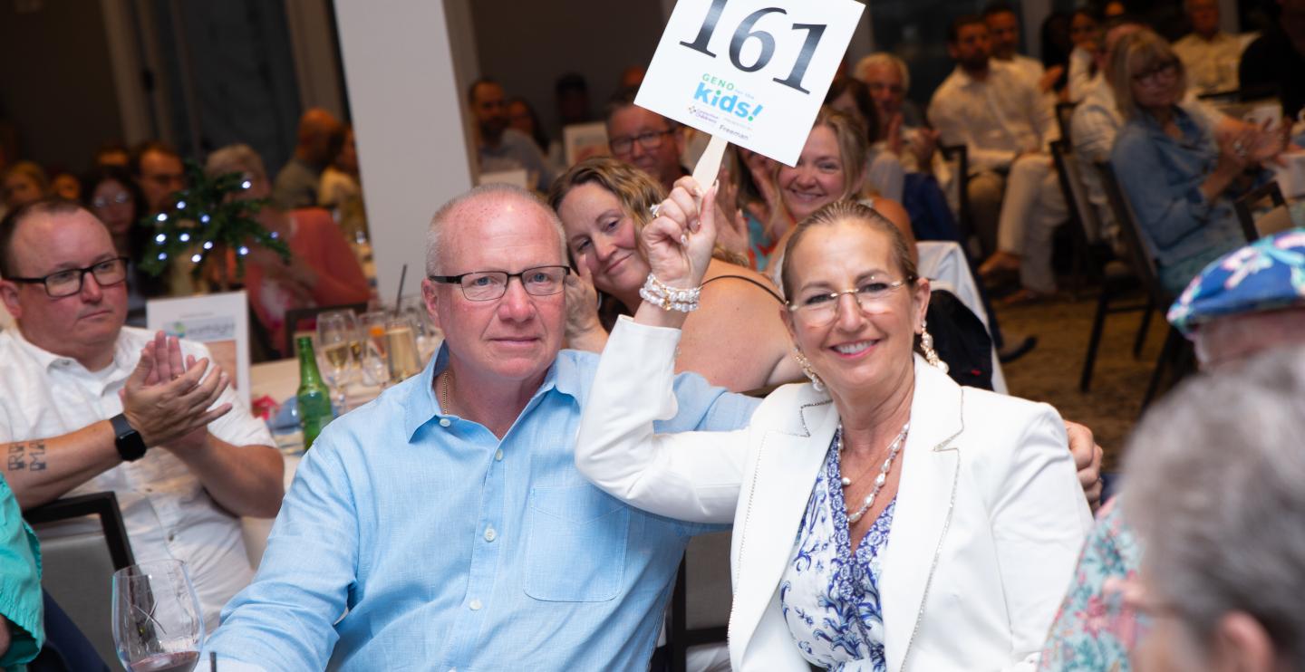 Guests bidding on an auction item and holding up their paddle