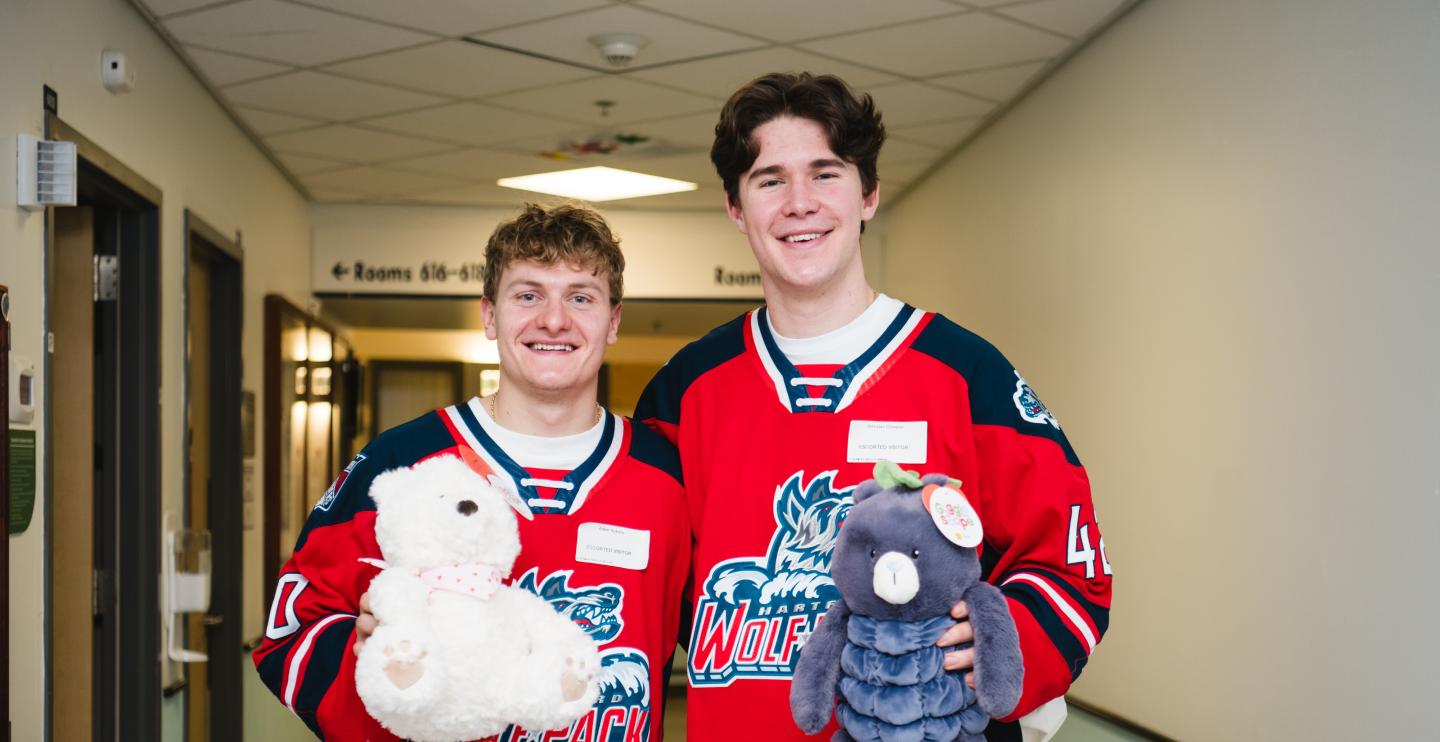 Hartford Wolfpack Player in jerseys with stuffed animals